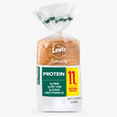 A clear plastic bag contains a loaf of Lewis Bake Shop protein bread, labeled with nutritional information highlighting 11 grams of protein per slice, 9 grams of fiber, and 1 gram of net carbs.